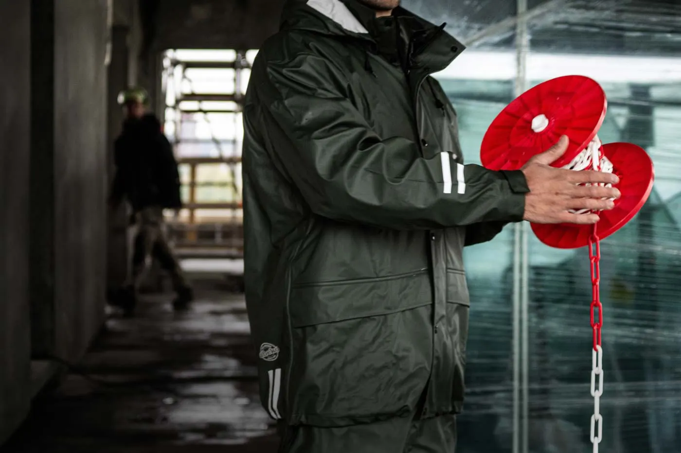 Person in dunkler Arbeitsjacke mit Reflexstreifen